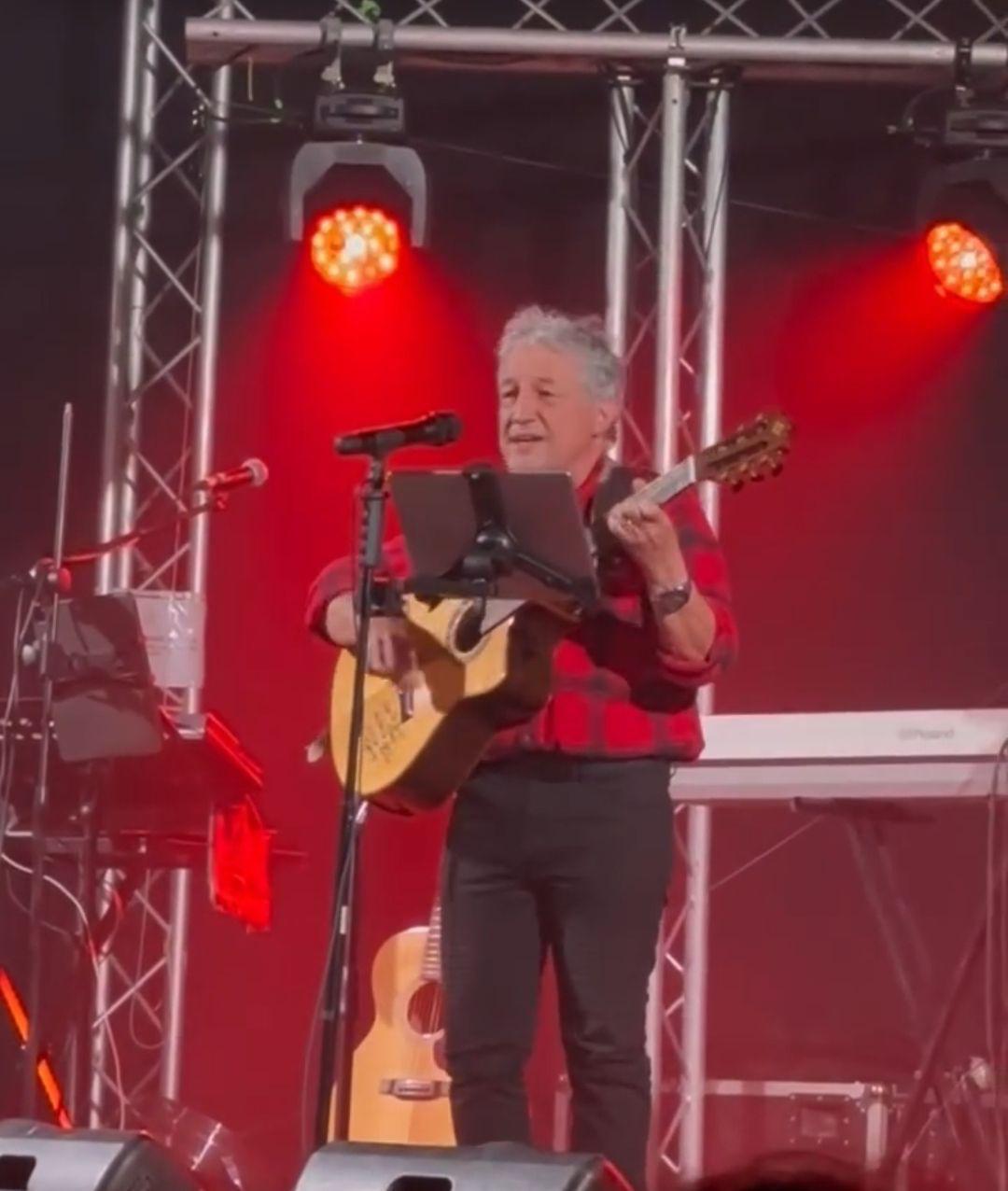 Tony Sampieri jouant de la guitare avec un ami, en intérieur