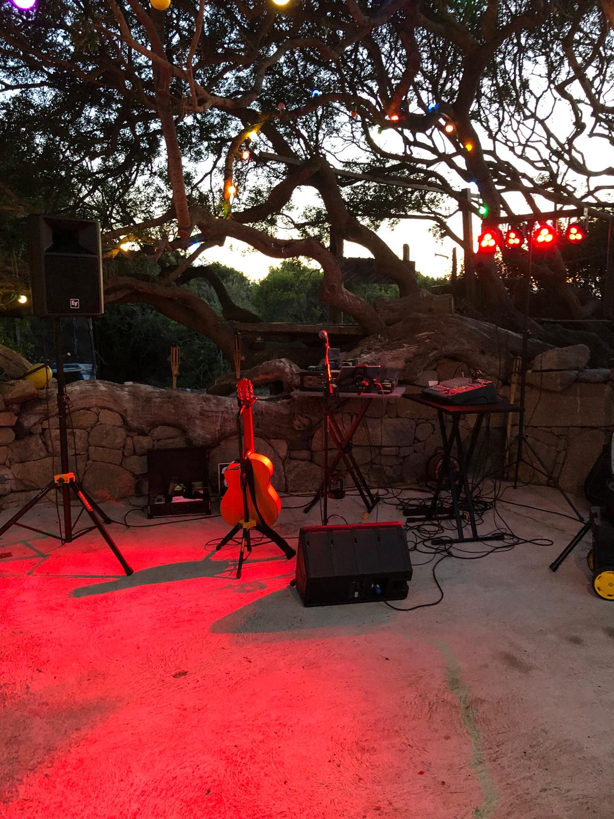 Scène de concert en plein air sous les arbres, éclairage rouge