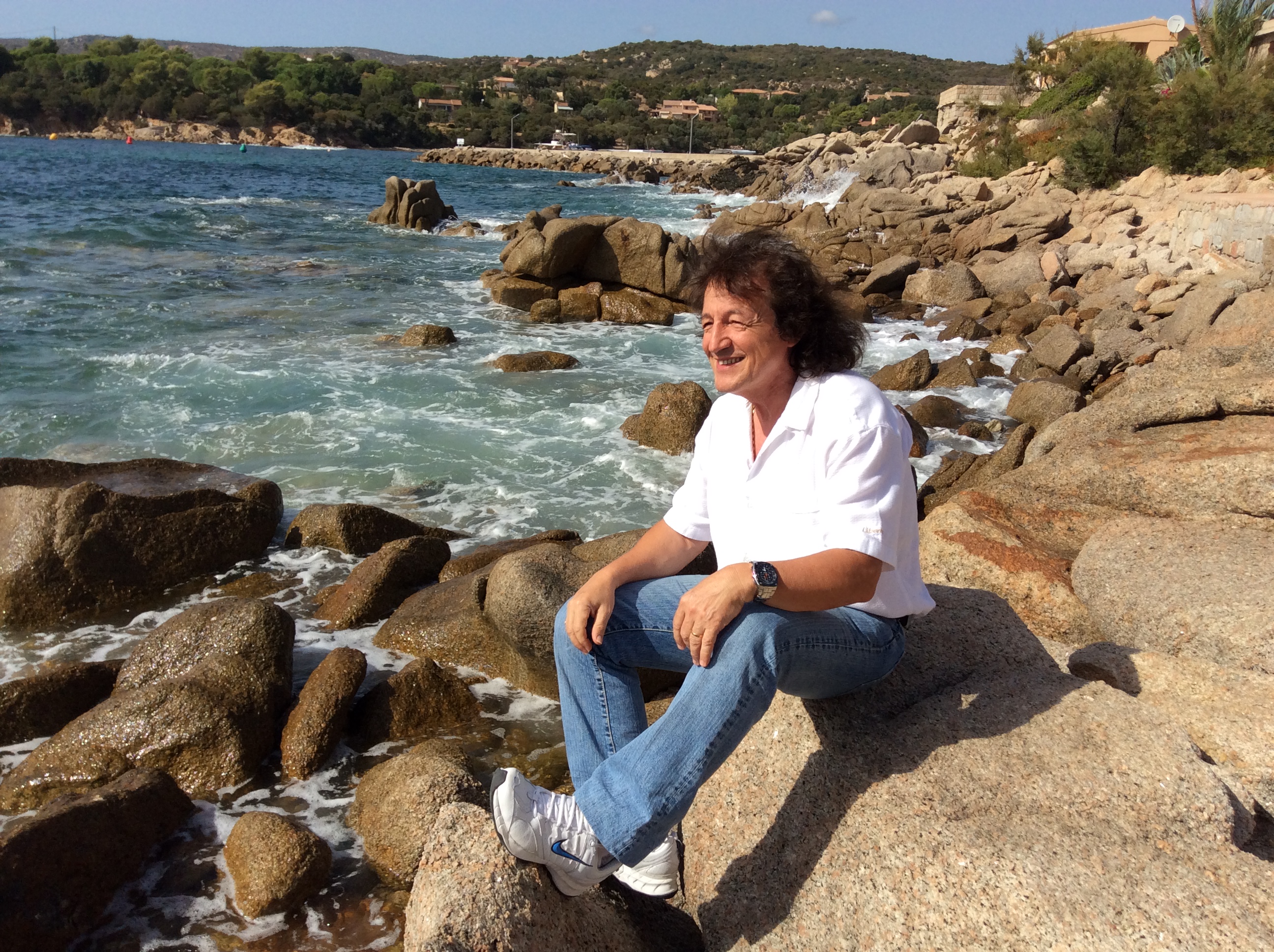 Tony Sampieri assis sur les rochers au bord de la mer